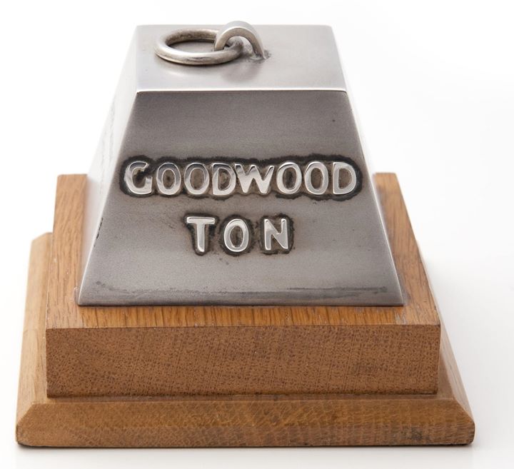 The Trophy of the Month. 
This month is the Goodwood Ton . Presented to Bruce for averaging the ton 100 mph around the 2.4 mile Goodwood race track driving a Cooper T 55 in the Glover Trophy Race. Bruce finished second with Graham Hill the winner. The British Automobile Racing Club (BARC) event held on Easter Monday April 23rd 1962 was a Non Championship Formula 1 race.
The trophy is engraved Bruce McLaren Cooper-Climax 103.6 mph. Easter Monday 23rd April 1962.
Bruce in car 4.
The trophy is 3 inches high, silver pyramid over wooden base.